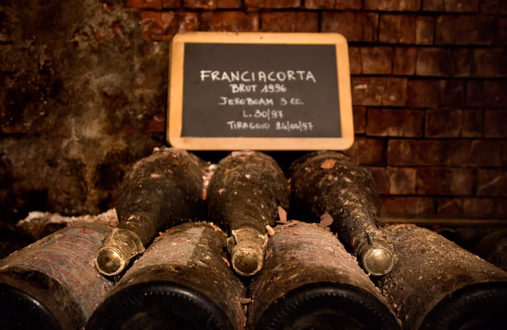 from-bergamo-food-and-wine-experience-in-franciacorta-cellar-visit Old 1996 Franciacorta wine laying on a cellar, in Franciacorta wine region, Lombardy